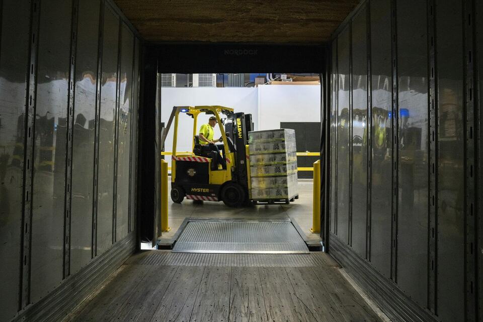 Forklift loading pallets into a dry van trailer at a warehouse dock