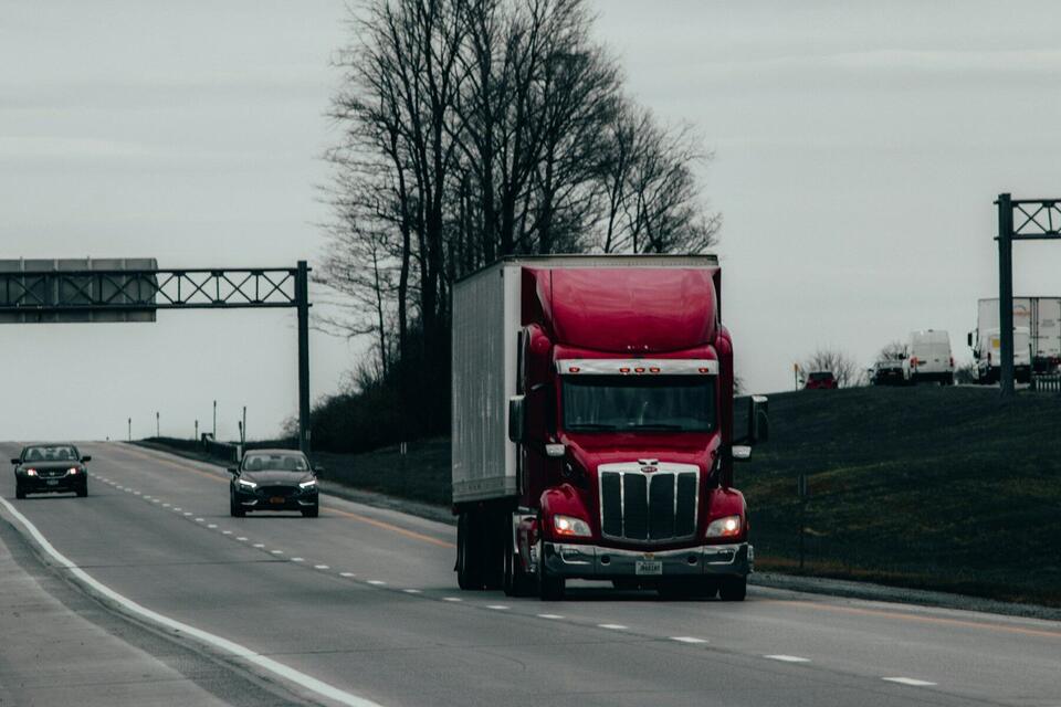 Red Peterbilt tractor with dry van trailer on a US interstate