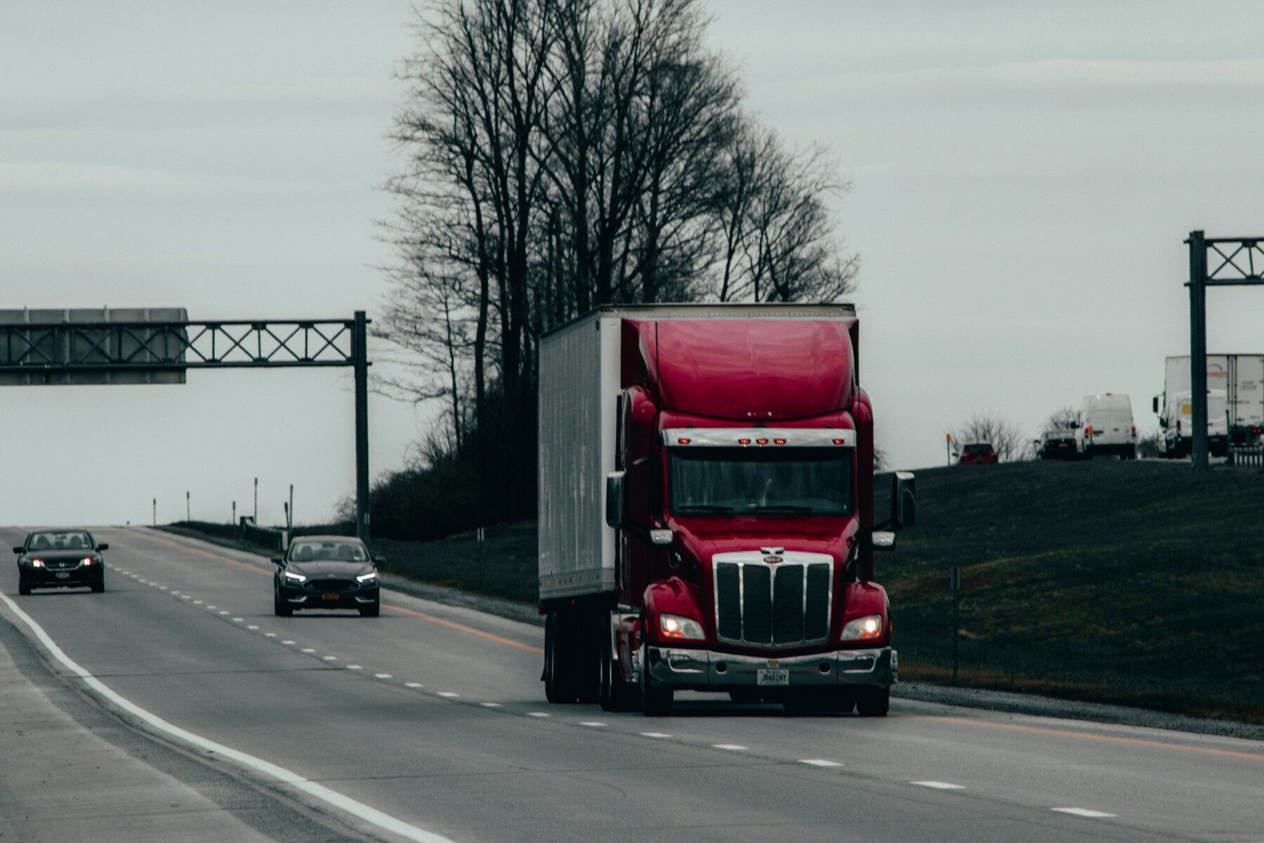 Semi truck with a dry van trailer driving on an interstate highway