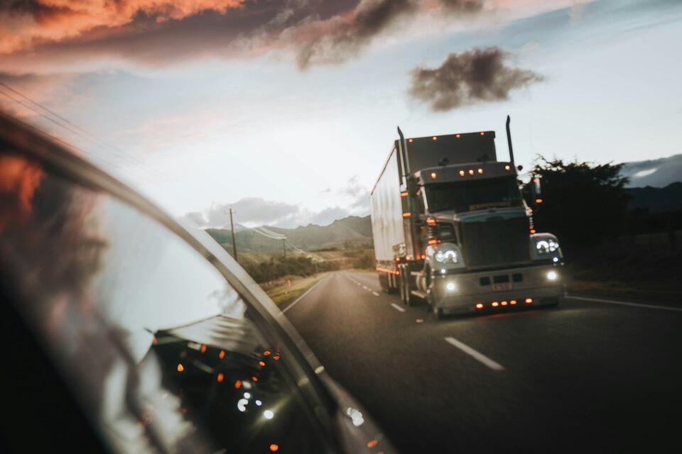 Peterbilt semi truck approaching on a rural highway at dusk